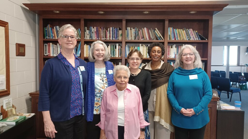 Women standing together in front of a library bookshelf