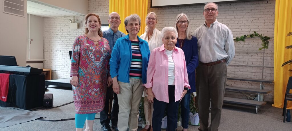 Seven community members standing together on the sanctuary stage